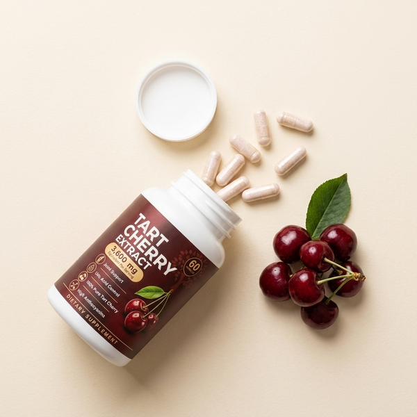 Flat lay of Ravea capsules spilling from the bottle beside tart cherries